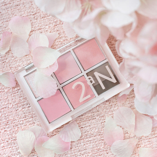 2AN  Better Me Eye Palette 4.5g, palette yeux rose posée sur tissu et pétales blancs, mise en scène beauté.