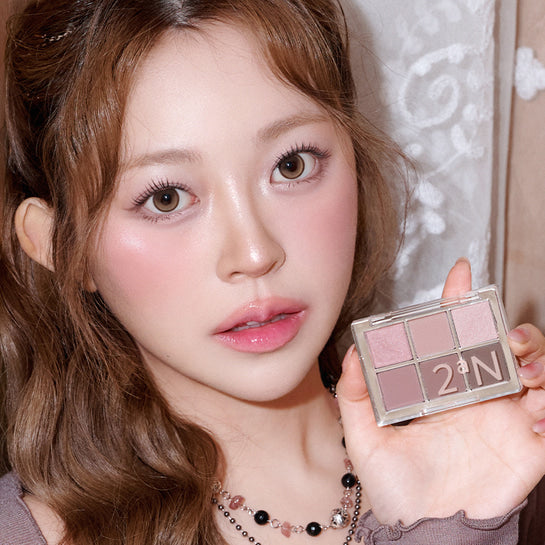Portrait maquillage : 2AN  Better Me Eye Palette 4.5g de la marque 2AN, palette yeux tenue près du visage, lumière douce.