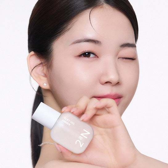 Décris l'image en français : 2AN Silky Veil Primer de 2AN, sur peau lisse, maquillage studio fond clair.