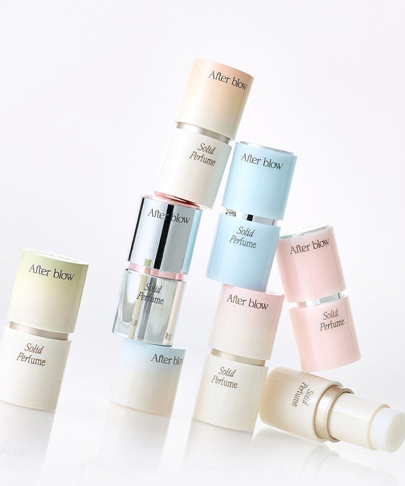 Décris l'image en français : AFTER BLOW Solid Perfume 6.5g, plusieurs baumes sur fond clair, style boutique.