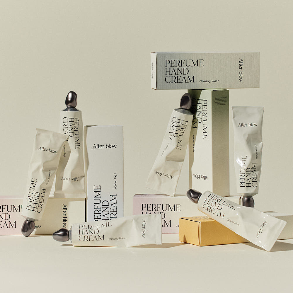 AFTER BLOW Perfume Hand Cream 50ml, marque AFTER BLOW : crème mains parfumée sur fond beige, packlets visibles.