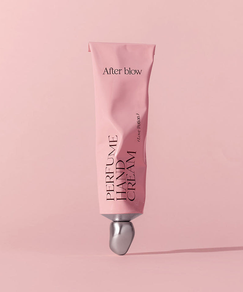 AFTER BLOW Perfume Hand Cream 50ml, tube rose After blow sur fond pastel rose, mise en scène beauté en douceur