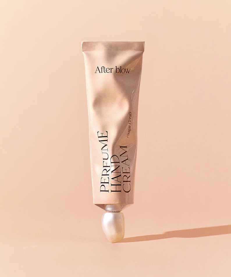 AFTER BLOW Perfume Hand Cream 50ml, tube crème parfumée de la marque After blow sur fond beige, photo produit.