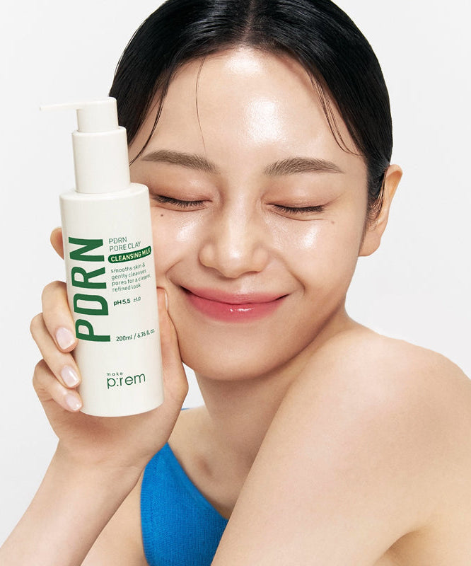 Femme souriante tenant MAKE P:REM PDRN Pore Clay Cleansing Milk 500ml, pour une peau éclatante et nettoyée en profondeur.