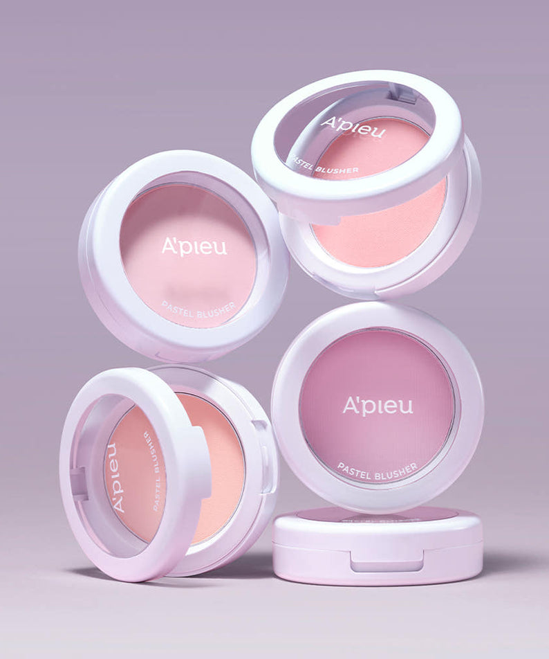 A'PIEU Pastel Blusher 4,3g, boîte et flacons roses sur fond mauve pastel, rendu maquillage studio