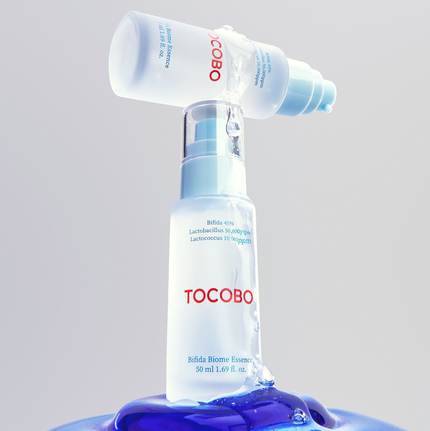 TOCOBO Bifida Biome Eessence de la marque TOCOBO sur fond clair, flacon et pompe avec essence bleue