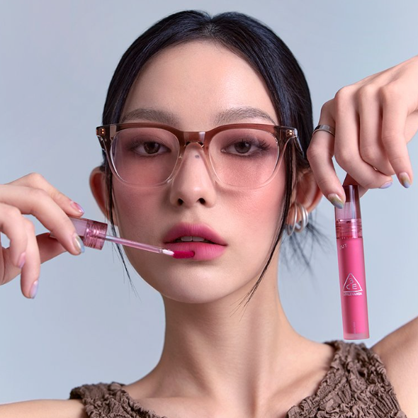 3CE Blur Water Tint 3 Shades : femme maquillée tenant le produit, teinte rose sur fond clair, look visage naturel.