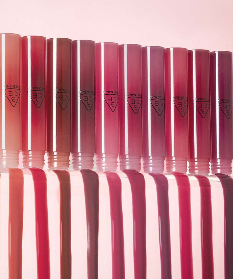 3CE Drop Glow Gel 10 Shades, tubes brillants en dégradé rouge sur fond rose, pack produit de la marque 3CE.
