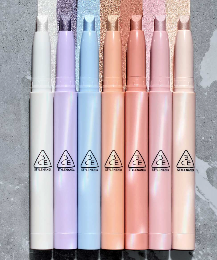 3CE Eye Switch Stick de 3CE sur fond marbré, photos en rangée de sticks colorés pour les yeux.