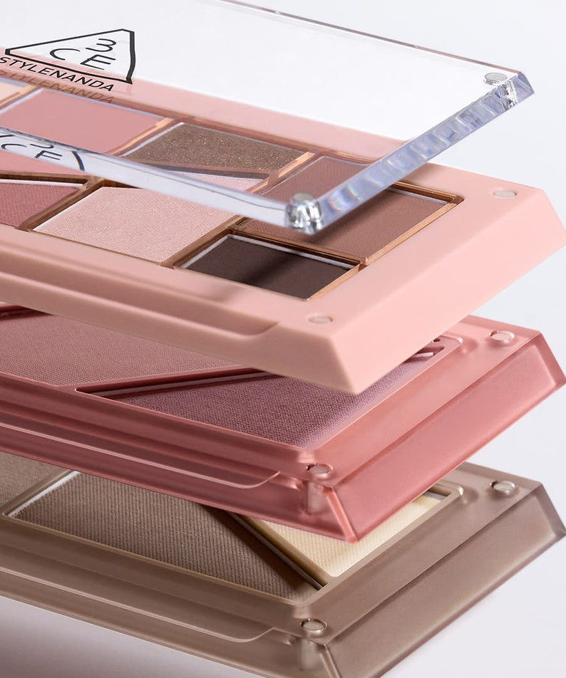 3CE Layer It All Contour Palette 9.5g, palette contour maquillage 3CE sur présentoir rose avec reflets sous lumière.