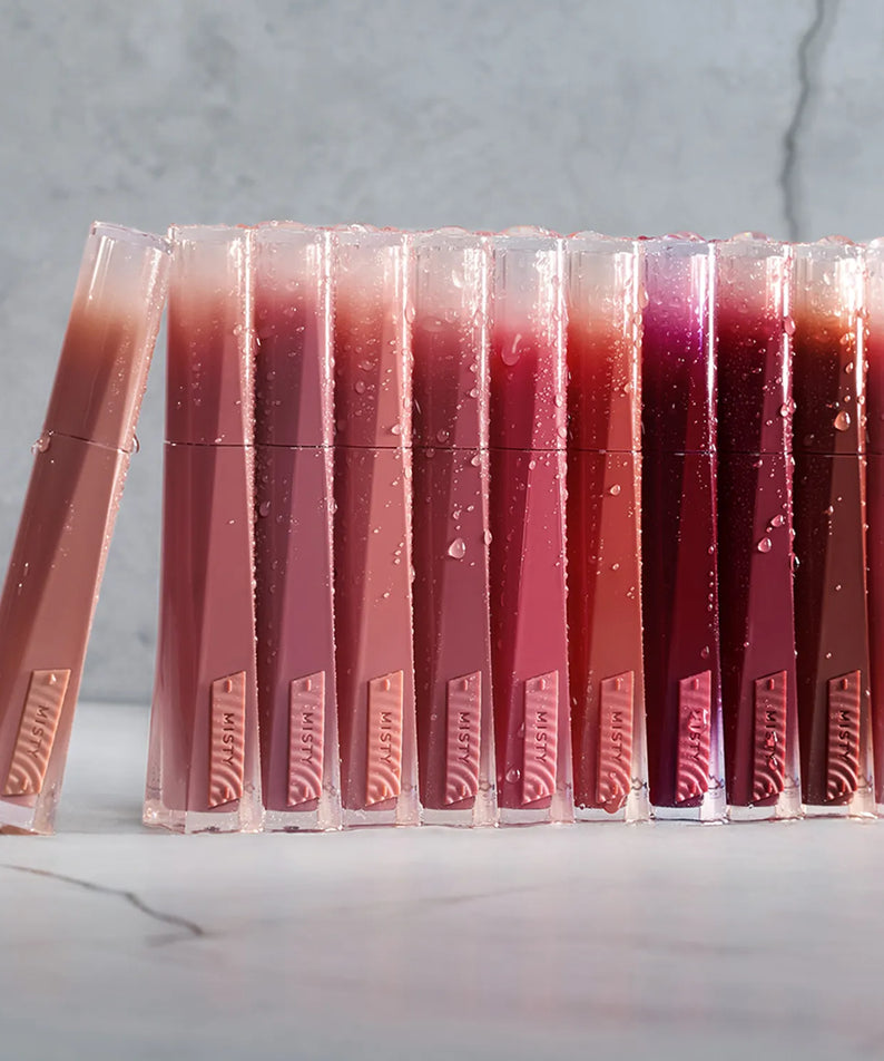 3CE Misty Lip Bare, gamme de baumes à lèvres nude en présentoir sur fond marbre, vue produit marque 3CE.