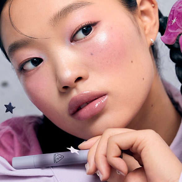 Gros plan maquillage 3CE Shine Reflector 8 shades : lèvres brillantes 3CE sur fond violet et étoiles, portrait beauté.