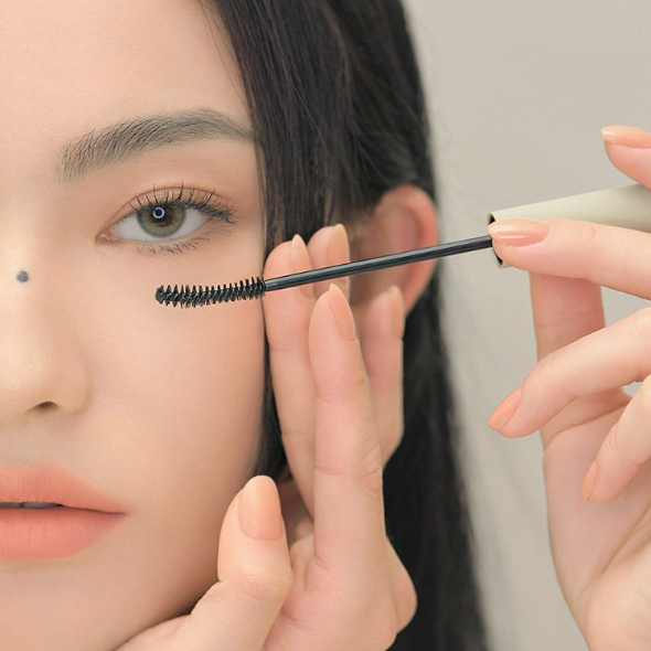 Appliquer 3CE Slim Fix Waterproof Mascara sur les cils, brosse tenue en gros plan, marque 3CE, maquillage waterproof
