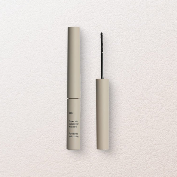 3CE Super Slim Waterproof Mascara, flacon beige et brosse noire sur fond clair, maquillage yeux en gros plan.