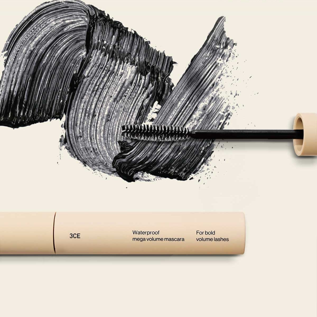 3CE Waterproof Mega Volume Mascara, gros plan tube et brosse sur maquillage noir, contexte beauté, étiquette 3CE visible