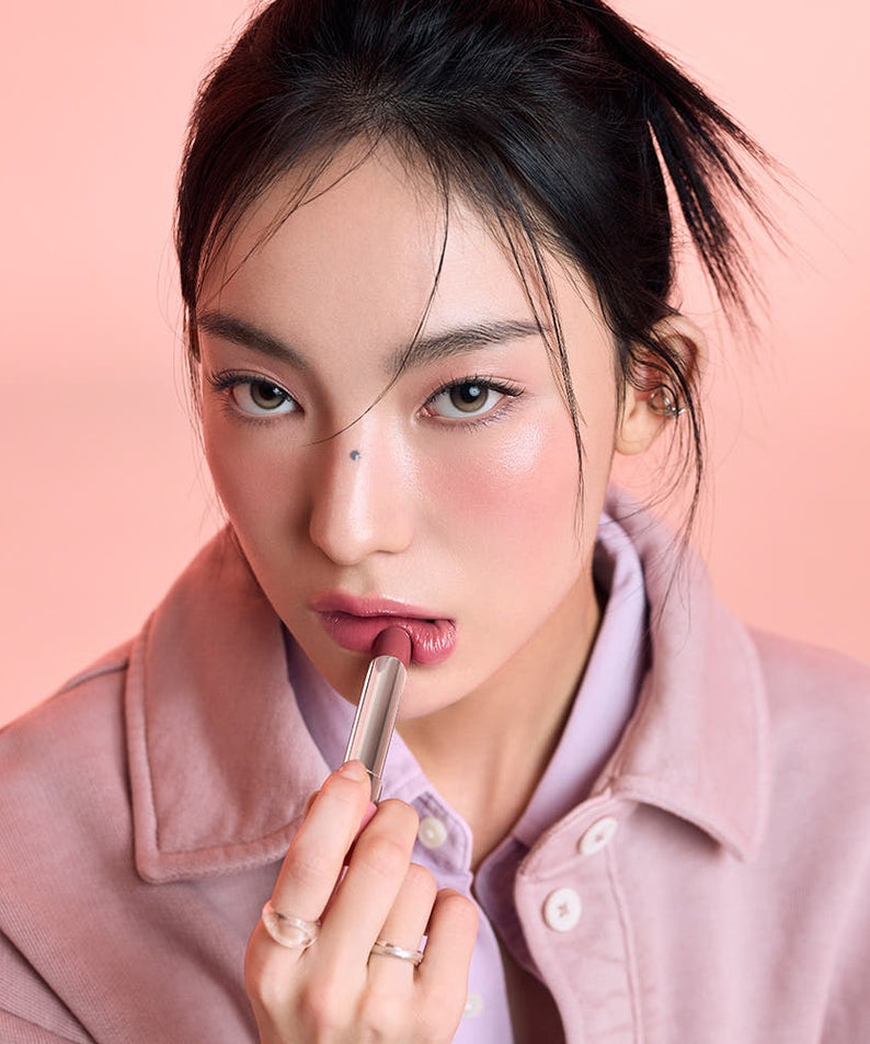 Femme appliquant 3CE Glaze Lip Glow 3.2g pour des lèvres éclatantes et glamour.