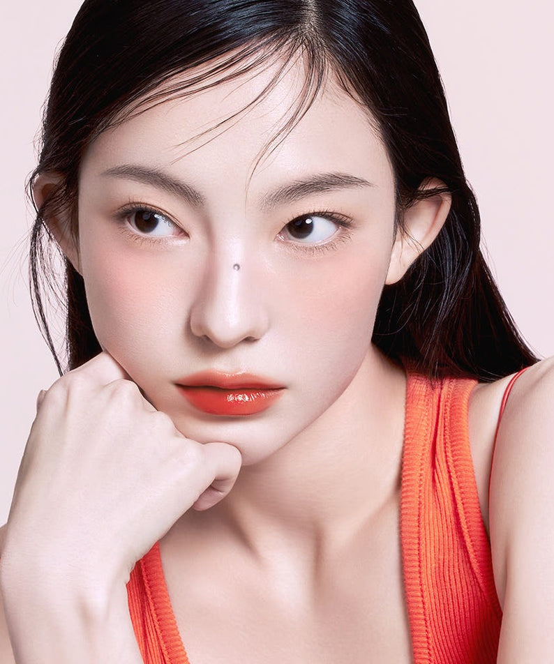 Femme portant 3CE Lazy Pop Lip Stain, teinte vibrante pour des lèvres éclatantes, maquillage moderne et élégant en gros plan.