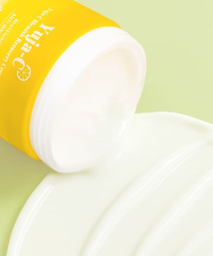 Pot de crème 3W CLINIC Yuja Seed Blemish Recovery Cream 110g ouvert, texture crémeuse étalée sur une surface vert clair.