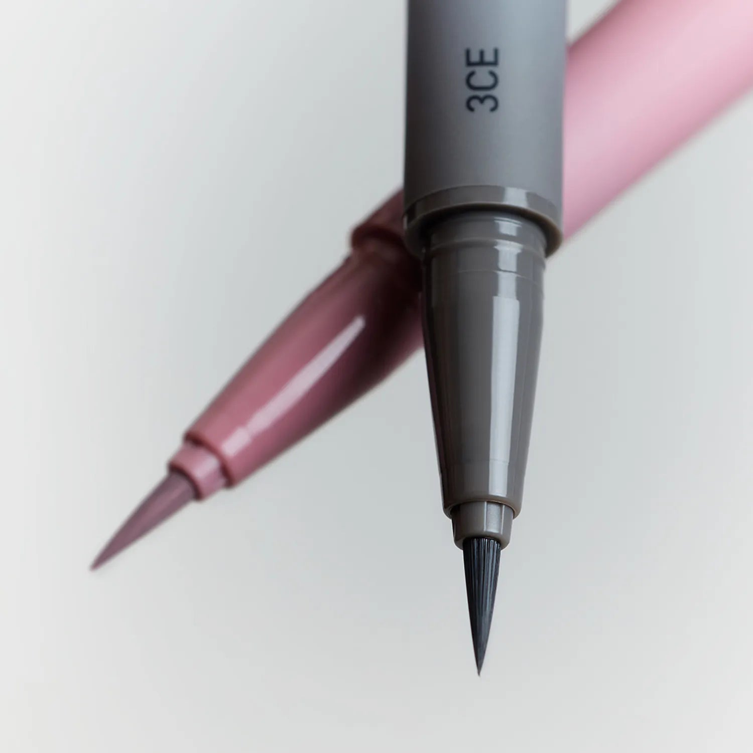 3CE  My Ring Eyeliner Duo, stylo noir 3CE avec pointe, maquillage des yeux sur fond rose, duo eyeliner liquide