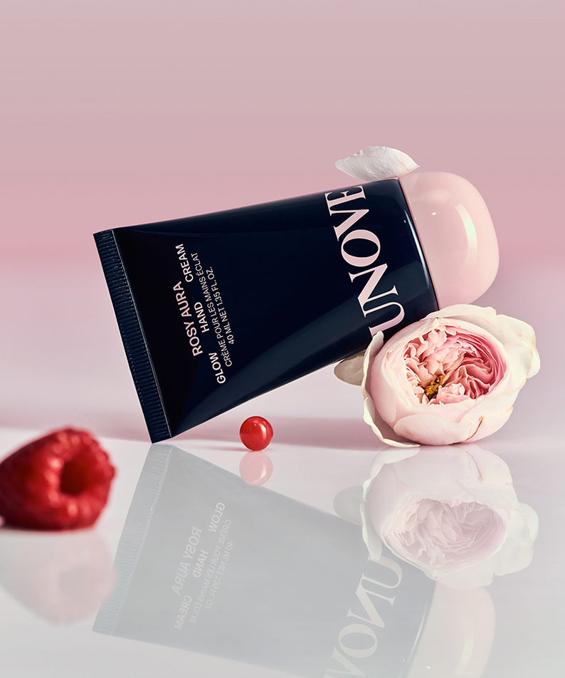 Tube de UNOVE Glow Hand Cream 40ml avec fleurs et fruits rouges sur fond rose élégant.