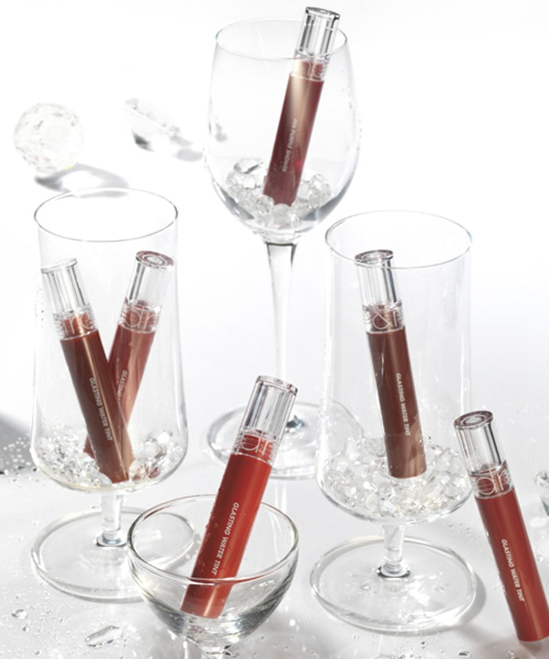 ROMAND Glasting Water Tint, flacon maquillage de la marque, éclaboussures d’eau sur fond blanc, style visuel produit