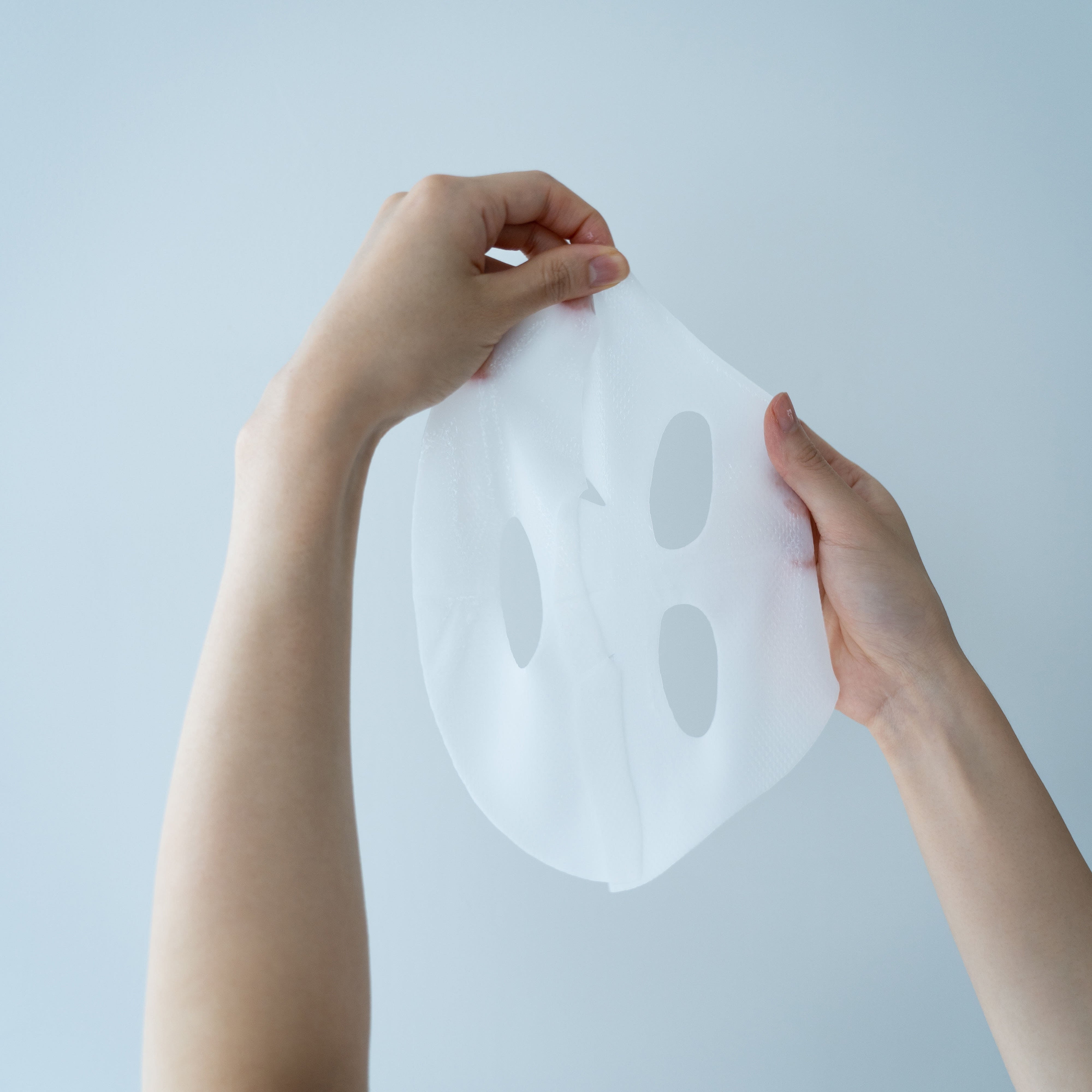 ABIB  Collagen Gel Mask Moisture Jelly 35g, masque en gel hydratant, mains ouvrant un sheet de masque sur fond bleu.