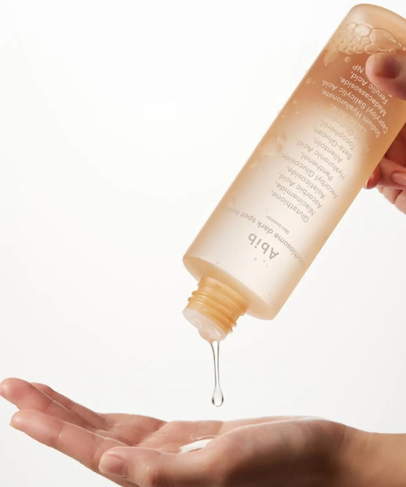 Photo produit : ABIB Glutathiosome Dark Spot Toner Skin Booster 200ml, main avec toner sur fond clair.