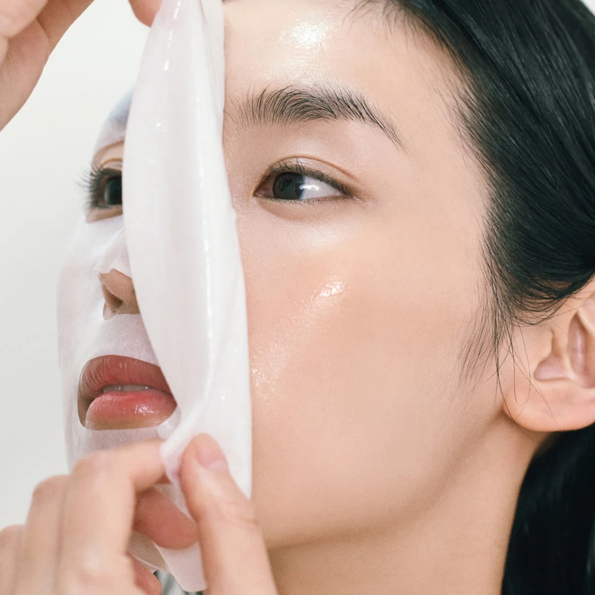 ABIB Gummy Sheet Mask Heartleaf Sticker : femme applique le masque en feuille, close-up peau hydratée.