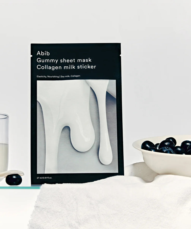 ABIB Gummy Sheets Mask Collagen Milk Sticker de la marque ABIB, photo sur table avec flacon de lait et grains bleus