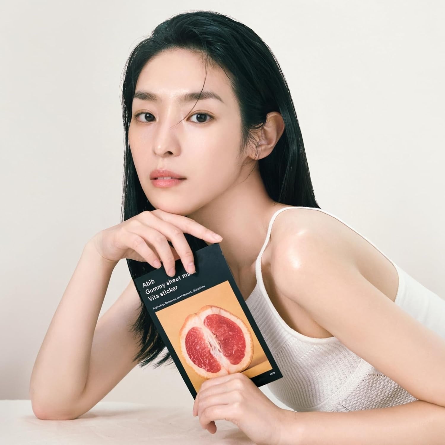 ABIB Gumy Sheet Mask Vita Sticker 10 sheets, la femme montre les gummies vita à l’écran, packaging sur fond clair