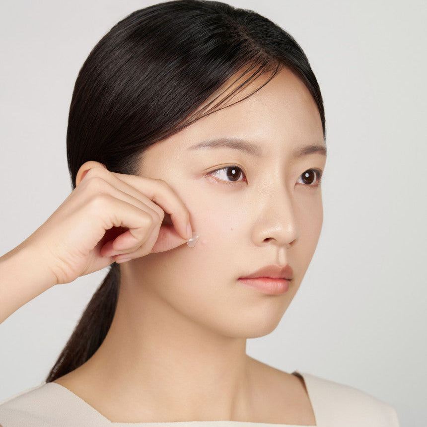ABIB  Heartleaf Calming Spot Patch 78 Patches : femme applique des patchs anti-imperfections sur le visage, fond clair.