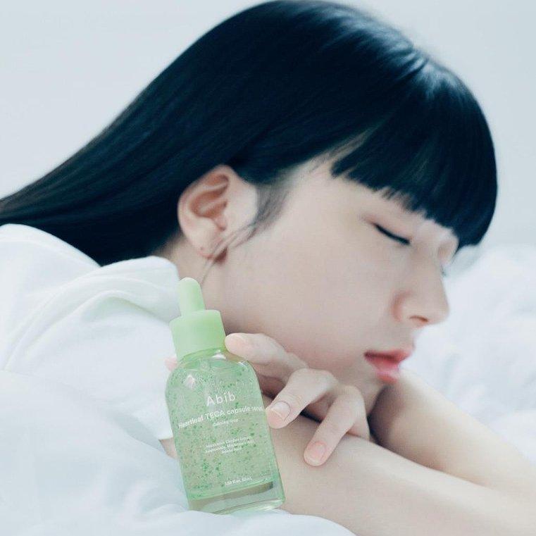 ABIB Heartleaf TECA Capsule Serum Calming Drop 50ml, marque ABIB, flacon apaisant sur peau, visage d’une femme au repos