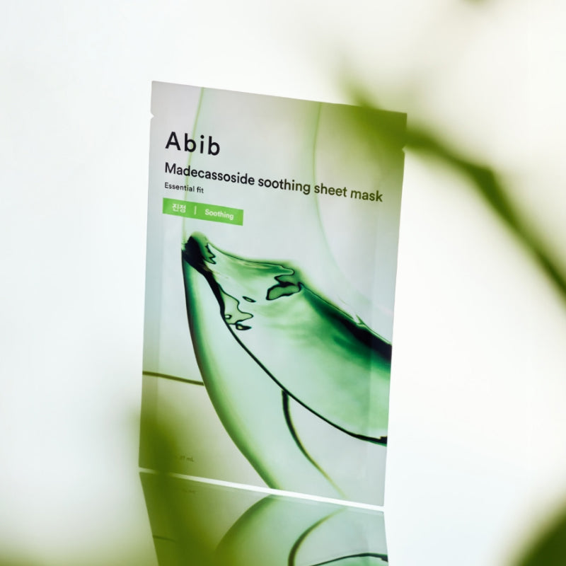 ABIB  Madecassoside Soothing Sheet Essential Fit, masque tissu apaisant Abib, sachet vert sur fond clair, feuille floue