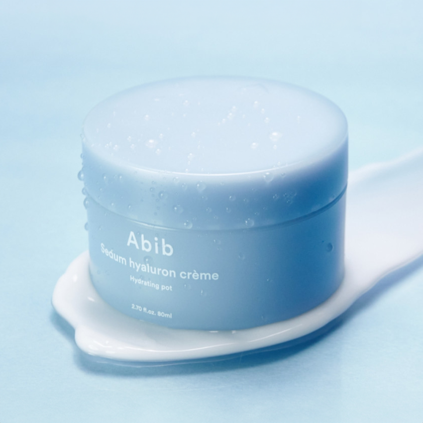 Décrivez l’image en français : ABIB Sedum Hyaluron Creme Hyadrating Pot 80ml, pot de crème sur fond bleu clair.