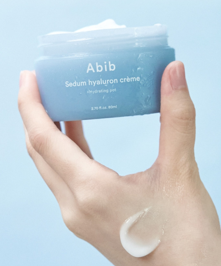 ABIB Sedum Hyaluron Creme Hyadrating Pot 80ml, mains tenant le pot bleu, crème hydratante sur fond clair