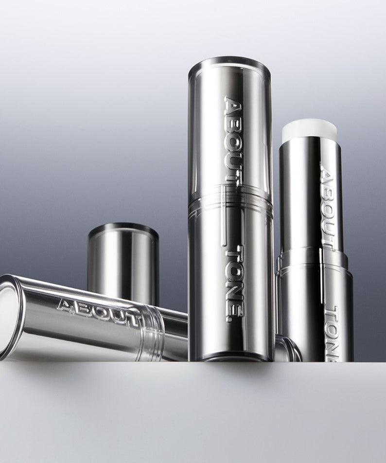 Bâtons de primer flou ABOUT TONE Blur Lasting Stick Primer en finition argentée élégante.