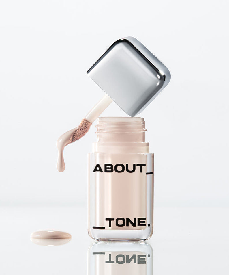ABOUT TONE  Skin Layer Cover Fit Concealer 5.6g, flacon distributeur et texture crème sur fond blanc.