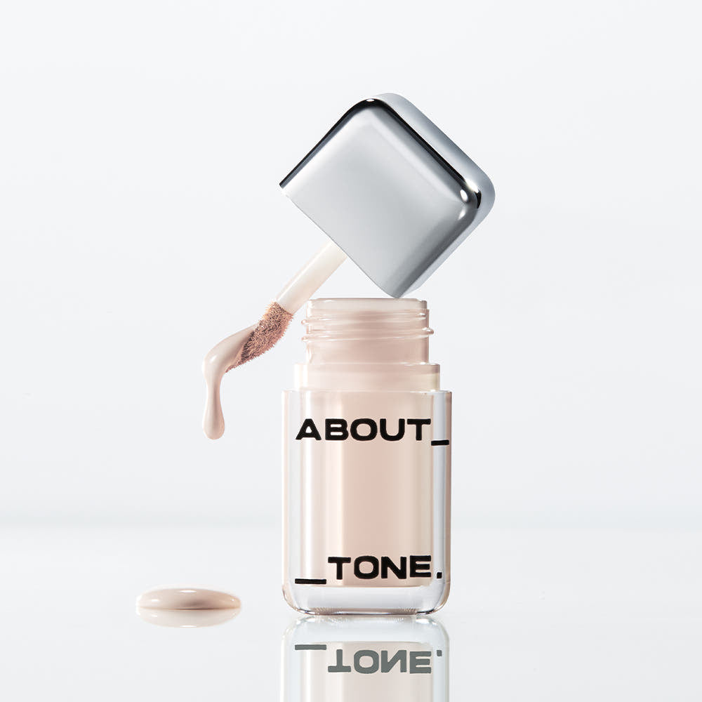 ABOUT TONE  Skin Layer Cover Fit Concealer 5.6g, flacon distributeur et texture crème sur fond blanc.