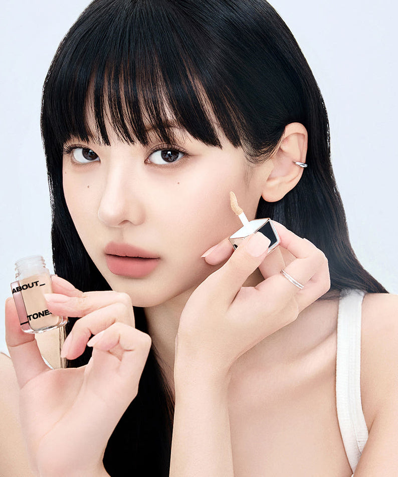 ABOUT TONE  Skin Layer Cover Fit Concealer 5.6g, marque ABOUT TONE, maquillage sur fond clair, femme applique le correcteur