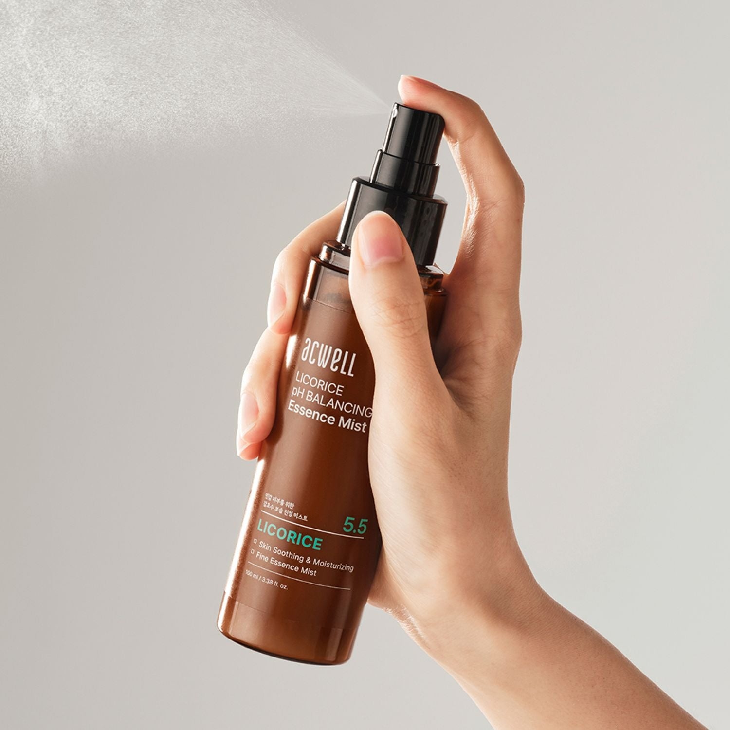 Main tenant ACWELL Licorice pH Balancing Essence Mist 100ml, spray brun à la réglisse, sur fond clair