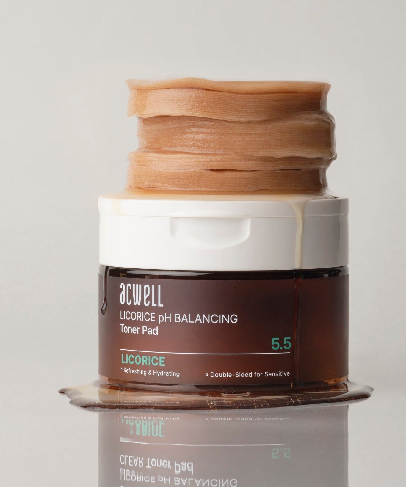 Pot de pads ACWELL Licorice pH Balancing Toner Pad 70P empilé, révélant leur texture hydratante et équilibrante pour le soin de la peau.