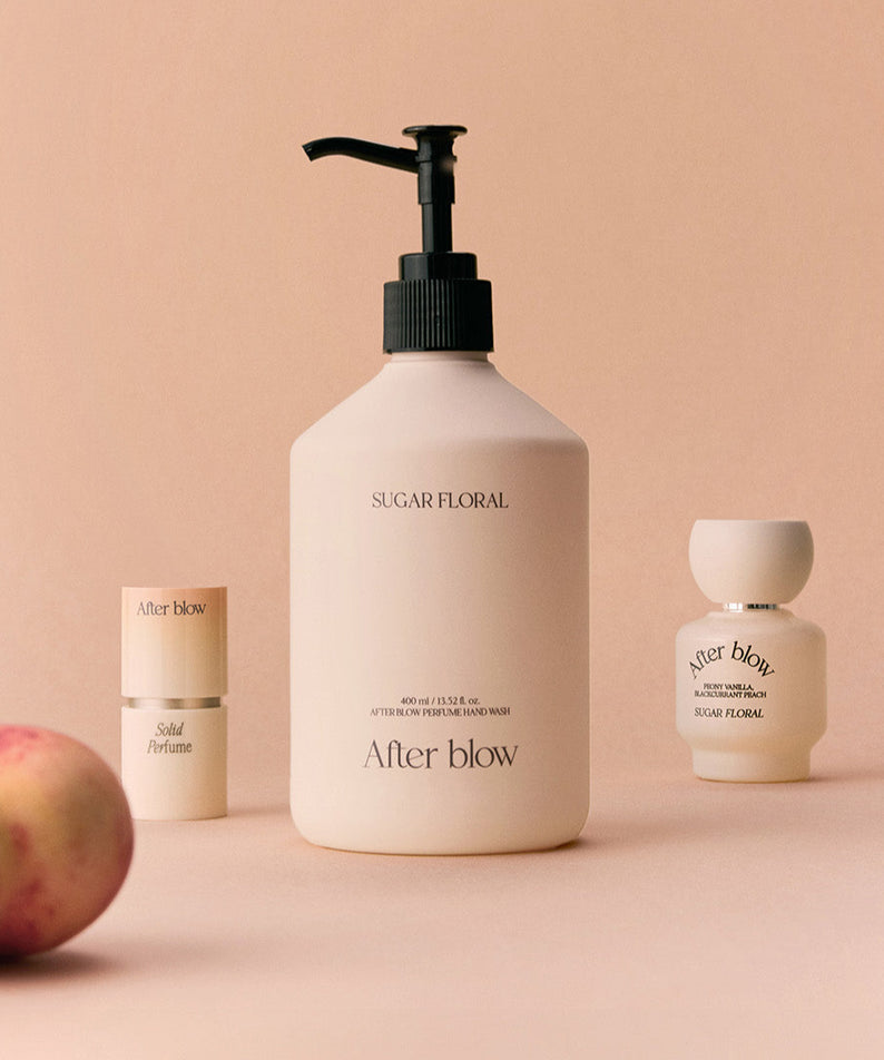 AFTER BLOW Perfume Hand Wash Sugar Floral 400ml : flacon de savon liquide et flacons assortis sur fond beige