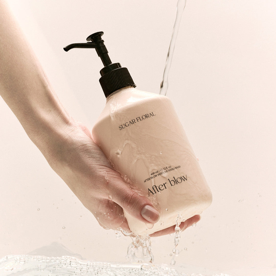 AFTER BLOW Perfume Hand Wash Sugar Floral 400ml : savon liquide parfumé en main, contexte visuel mains sous l’eau.