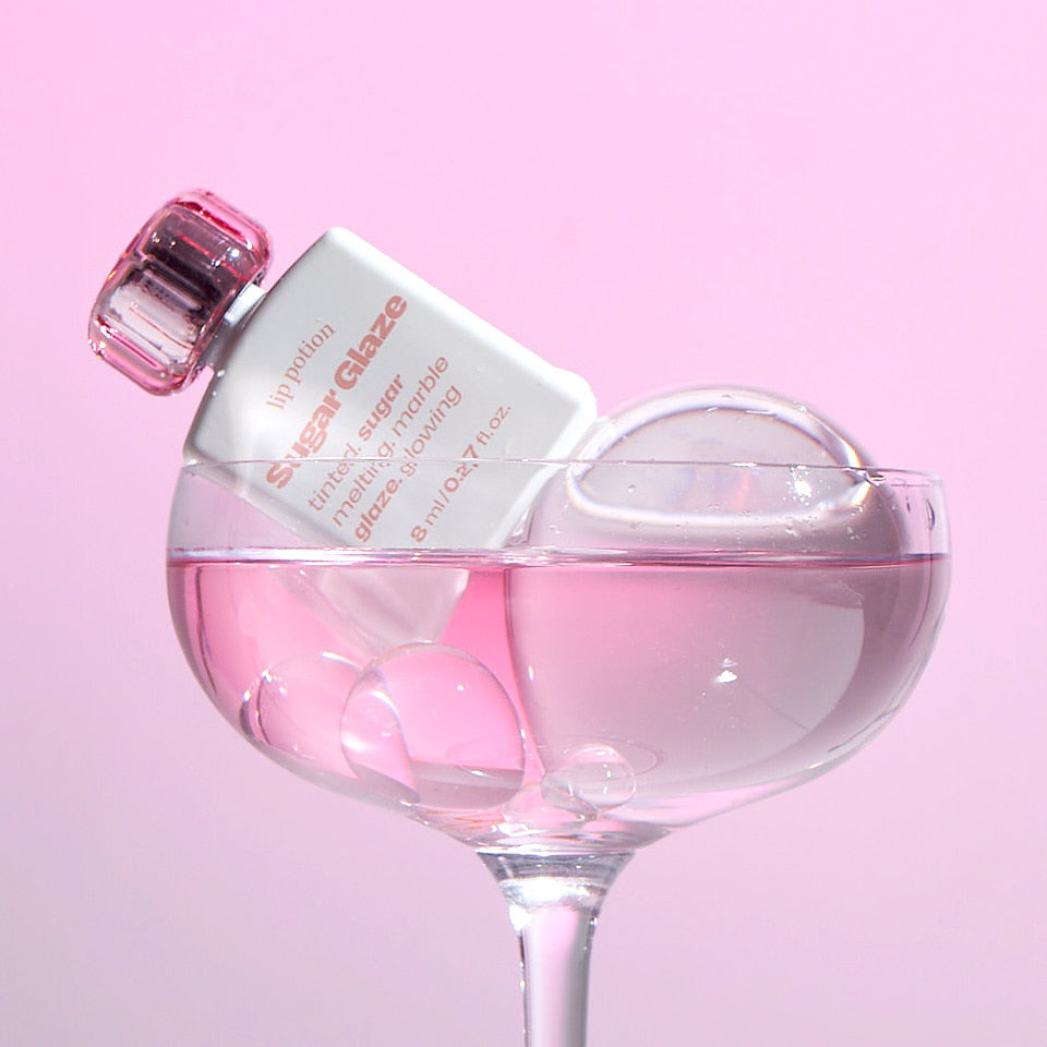 ALTERNATIVE STEREO Lip Potion Sugar Glaze Tint 8ml, produit de maquillage présenté dans un flacon rosé sur fond rose.