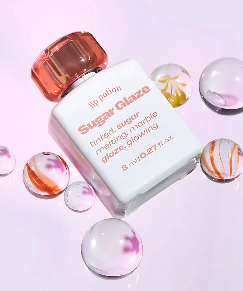 ALTERNATIVE STEREO Lip Potion Sugar Glaze Tint 8ml, flacon et billes colorées sur fond clair, vue produit marque Alternative