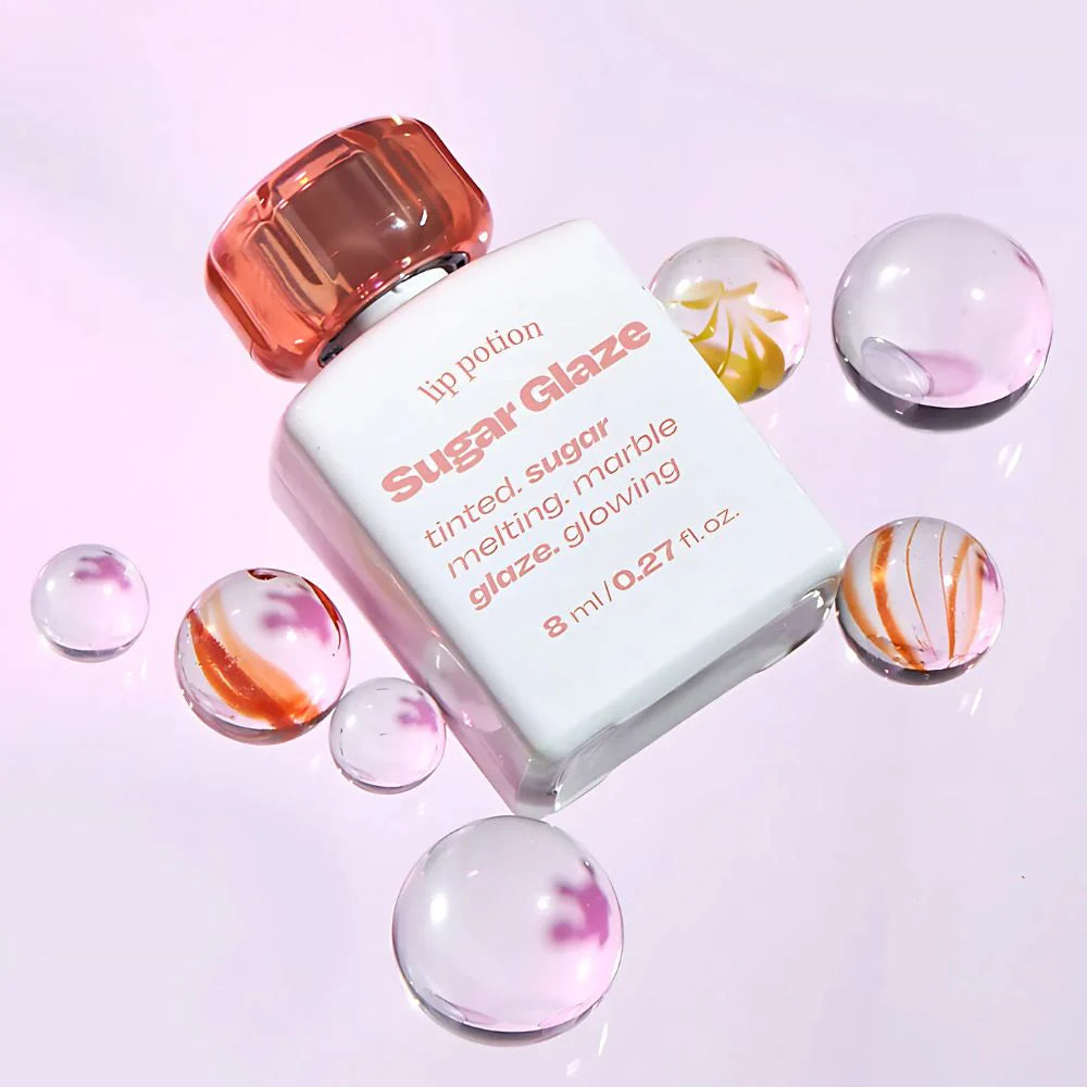 ALTERNATIVE STEREO Lip Potion Sugar Glaze Tint 8ml, flacon et billes colorées sur fond clair, vue produit marque Alternative
