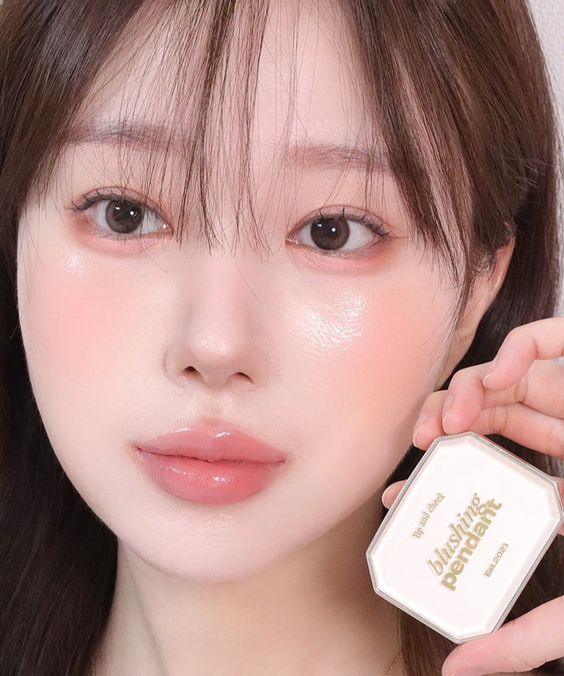 Femme utilisant ALTERNATIVE STEREO Blushing Pendant Lip & Cheeck, maquillage léger et élégant pour lèvres et joues.