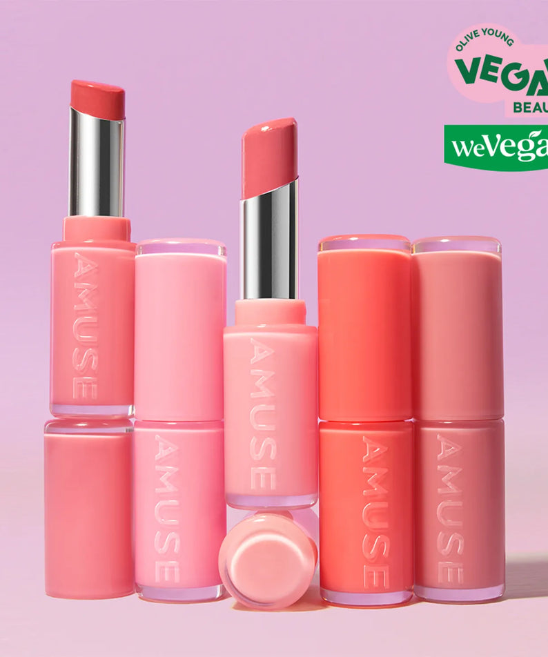 Rouges à lèvres AMUSE Fondue Balm en nuances roses, produits de beauté vegan présentés sur un fond pastel pour une touche glamour.