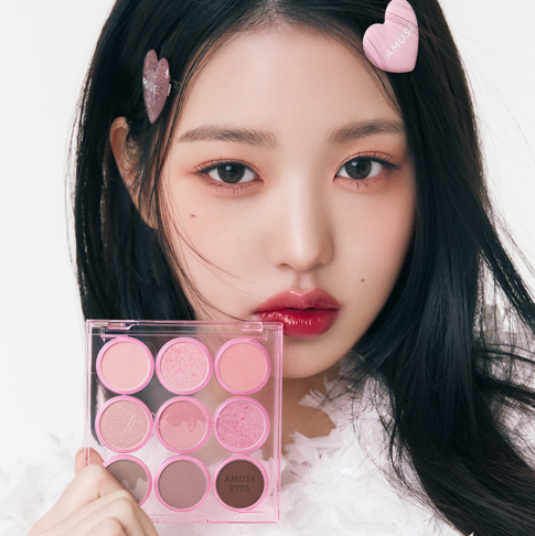 AMUSE Eye Color Palette de AMUSE : maquillage yeux rose sur modèle en studio, main tenant la palette, gros plan.