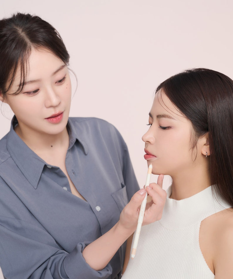 Utilisation du crayon correcteur AND:AR Soft Skinfit Dual Concealer Pencil sur une cliente, maquillage précis et naturel.